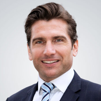 Herr Falkensteiner tr&auml;gt Anzug und Krawatte
